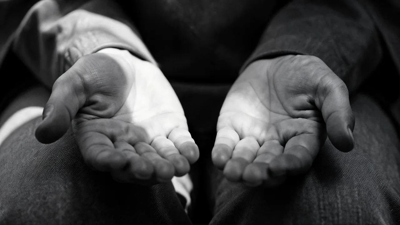 Primer plano de manos abiertas con palmas hacia arriba, una iluminada y otra en sombra, el espacio entre ellas es el foco, la pausa entre estímulo y respuesta, blanco y negro